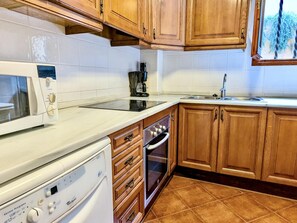 A kitchen with wooden cabinets, a microwave, a coffee maker, and a dishwasher. - House, sea view - 5 guests (Tossa de Mar)
