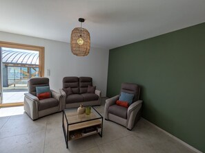 A modern living room with three armchairs, a glass coffee table, and a woven pendant light. - Mountain lodge with valley view (Le Val-d'Ajol)