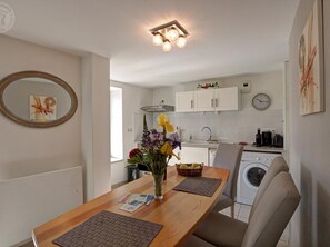 A modern kitchen with white cabinets, a sink, and a clock on the wall. - Modern lodge in natural surroundings - 4 guests (Usson-en-Forez)