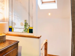 A room with a skylight, a wooden dresser, and a stained glass window. - Romantic Lyme Regis Couple's Hideaway (Lyme Regis)