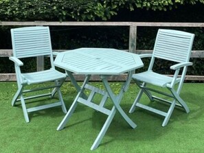A set of three light blue folding chairs and a matching table arranged on artificial green grass. - Romantic Lyme Regis Couple's Hideaway (Lyme Regis)