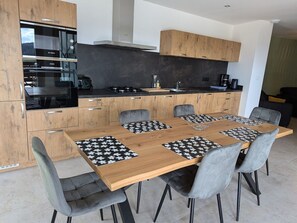 A modern kitchen with wooden cabinets, a black countertop, and a Bosch oven. - Cottage in the mountains with pool - panoramic view (Le Val-d'Ajol)