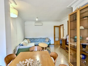A compact living space with a sofa, a dining table, and a cabinet. - Apartment with pool, pets OK - 6 guests (Tossa de Mar)