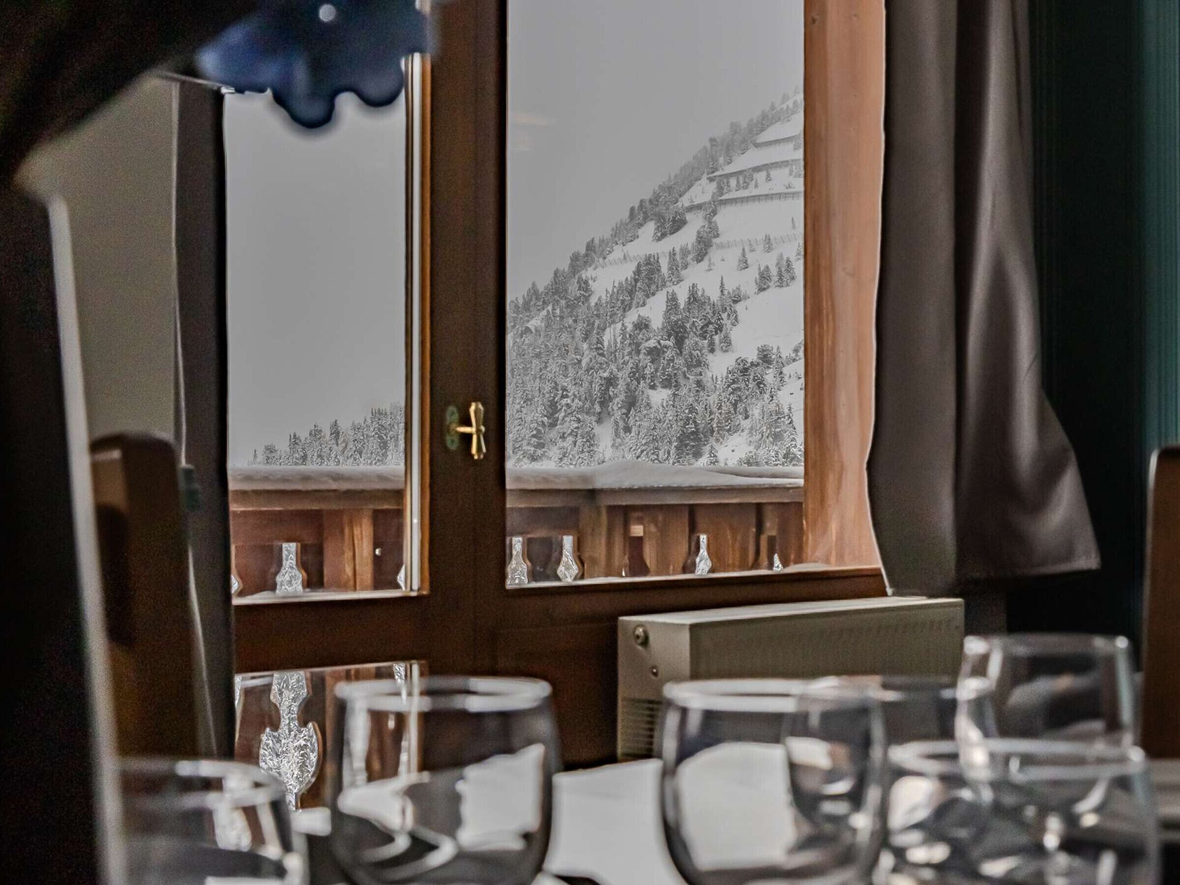 Comedor con vista a un paisaje nevado de montañas a través de una ventana.