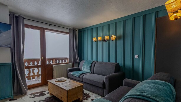 A living room with a sofa, a wooden coffee table, and a cowhide rug. - Cozy apartment, panoramic view - 8 guests (Belle Plagne)