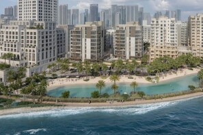 Ein Küstenhotel mit mehreren Hochhäusern, direkt am Strand und mit Palmen.