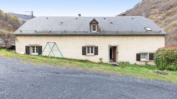 A single-story house with a sloped roof, a small window, and a door.