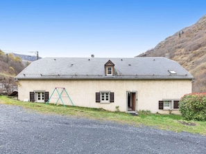 Ein eingeschossiges Haus mit geneigtem Dach, einem kleinen Fenster und einer Tür.