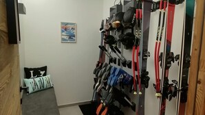 A room with a bed, a wall-mounted ski rack, and a poster. - Prestige chalet, mountain view - 10 guests (La Plagne Montalbert)