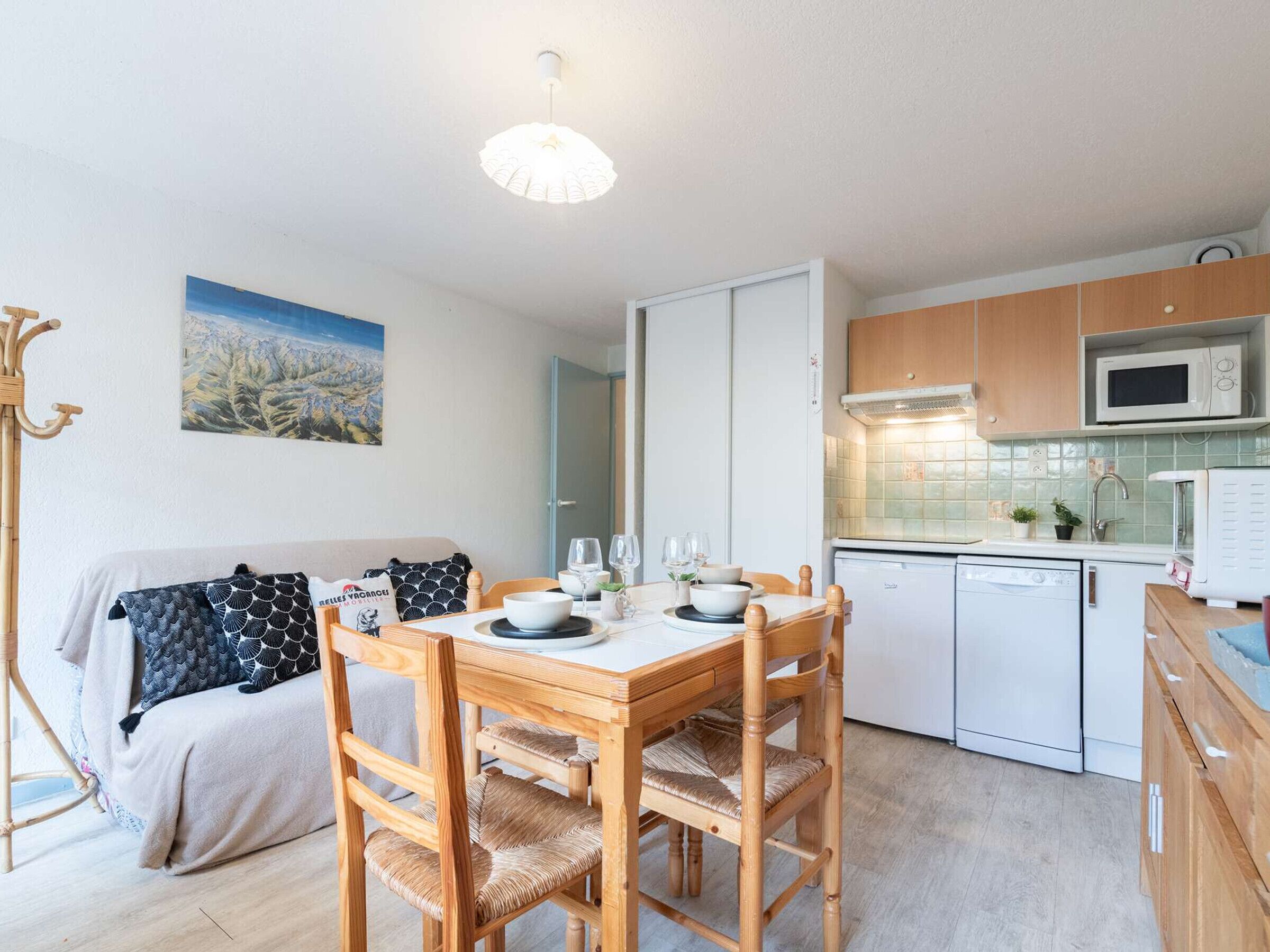 A compact kitchen with a dining table, chairs, a microwave, and a dishwasher.