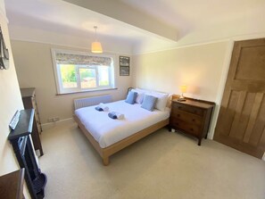 A bedroom with a bed, a dresser, a radiator, a window, and a door. - Near the River and Marinas, quick walk to town Large Garden and off street parking for 3 cars (Lymington)