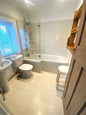 A bathroom with a glass-enclosed shower, a bathtub, two toilets, and a sink. - Near the River and Marinas, quick walk to town Large Garden and off street parking for 3 cars (Lymington)