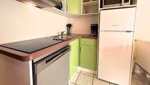 Una cuina compacta amb rentaplats, microones i cafetera.
