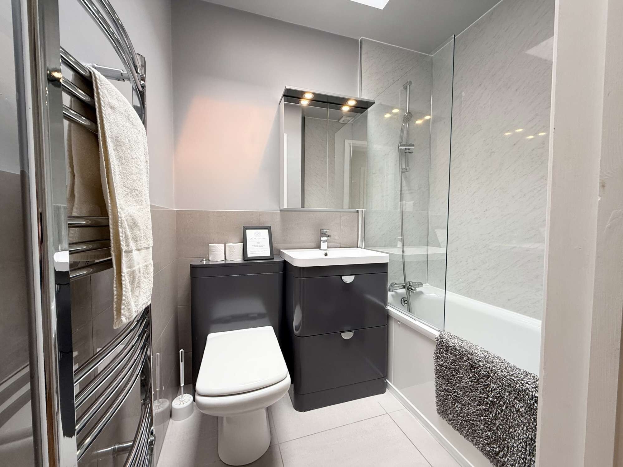 A modern bathroom with a toilet, sink, and shower.