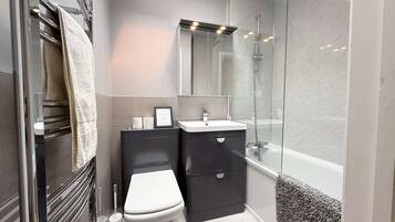 A modern bathroom with a toilet, sink, and shower.