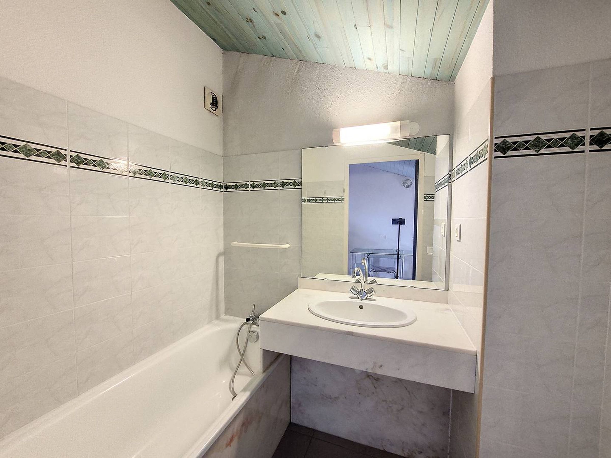Ein Badezimmer mit einer Badewanne, einem Waschbecken und einem Spiegel.