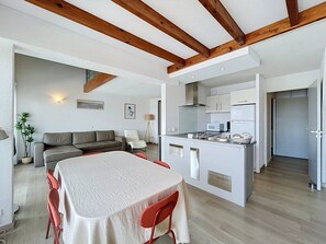 A compact living space with a dining area, kitchenette, and a sofa. - Spacious apartment, lake view - 8 guests (Vieux-Boucau-les-Bains)