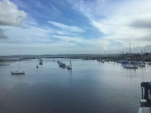 A marina with boats docked, calm water, and a clear sky. - Starboard Light by NewFo dot Rest (Lymington)