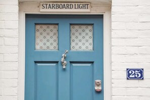 Uma porta azul com uma placa acima que diz 'STARBOARD LIGHT' e o número '25' exibido na parede à direita.