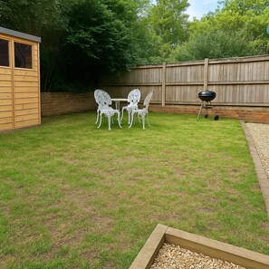 A backyard with a wooden deck, a barbecue grill, and a table with chairs. - Yew Tree Cottage – Direct New Forest Access, Ponies & Walk to Lyndhurst (Lyndhurst)