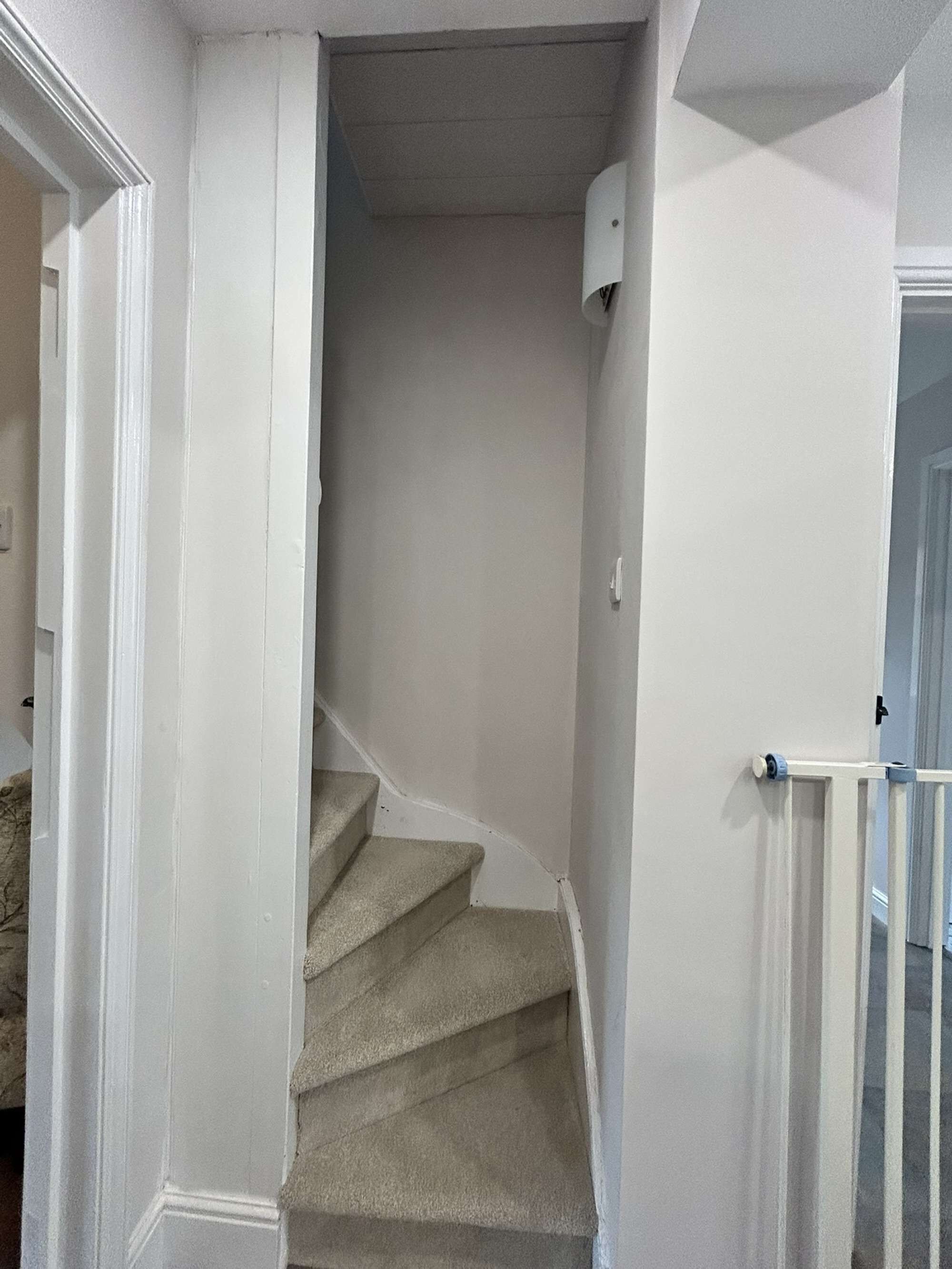 Un escalier avec une rampe et une porte en haut.