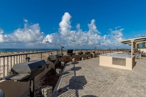 A rooftop terrace with barbecue grills, seating areas, and a view of the beach. - Phoenix X 908 1 Bedroom Condo (Orange Beach)