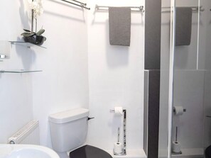 A modern bathroom with a toilet, bidet, glass shelf with a plant, and a towel rack. - 3-bedroom Cottage Near Coast (Bude)