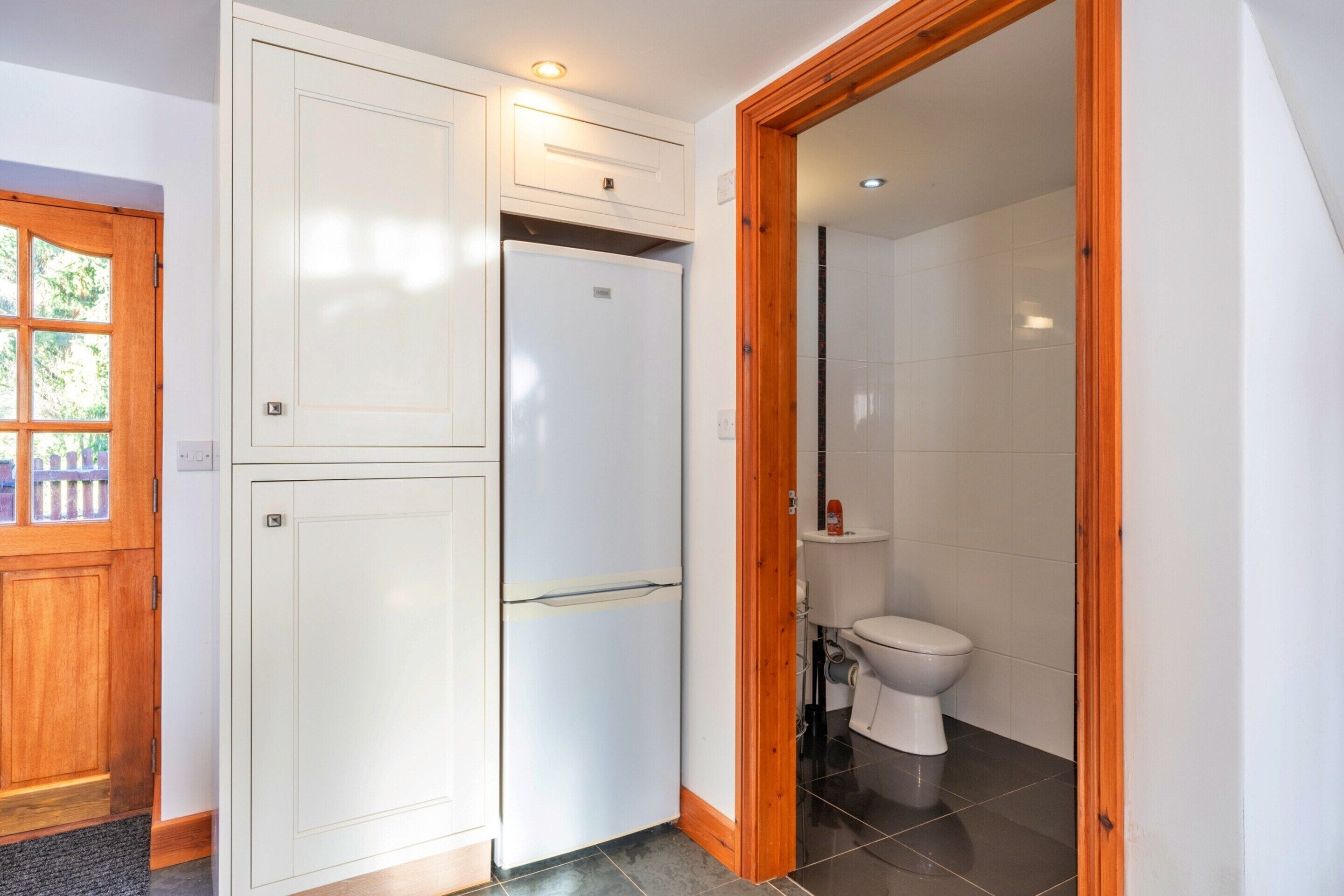 A compact bathroom with a toilet, a sink, and a cabinet.
