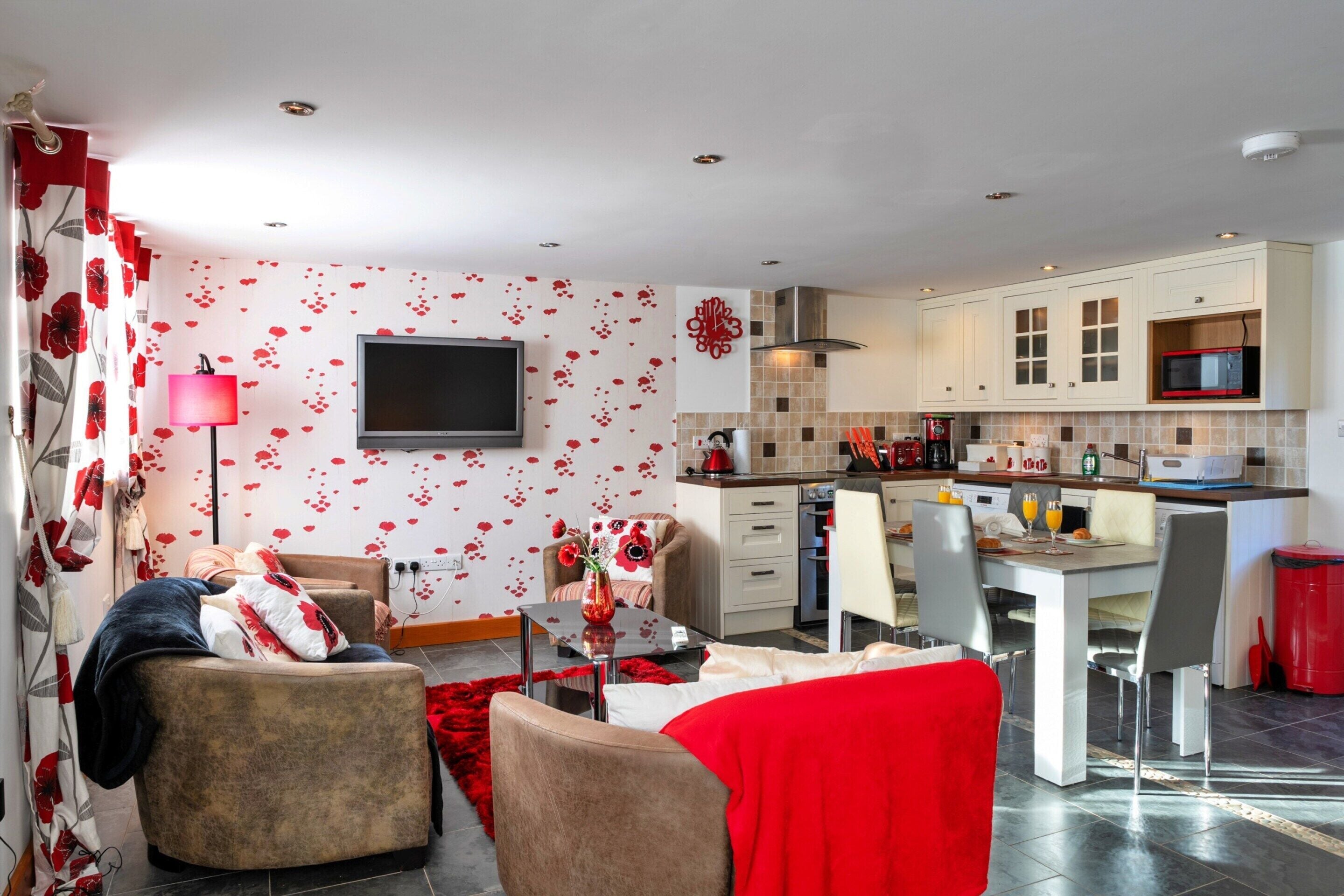 Ein modernes Wohnzimmer mit Fernseher, Sofa und Couchtisch.