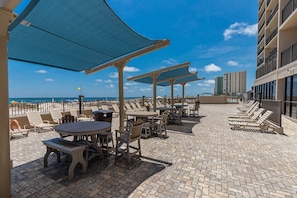 A rooftop patio with outdoor seating and a view of the ocean. - Phoenix X 1008 1 Bedroom Condo (Orange Beach)