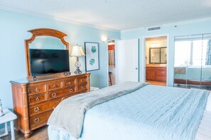 A bedroom with a large bed, wooden dresser, and a television. - 705 S Hampton Oceanview Retreat With Balcony 2 Bedroom Condo (Myrtle Beach)