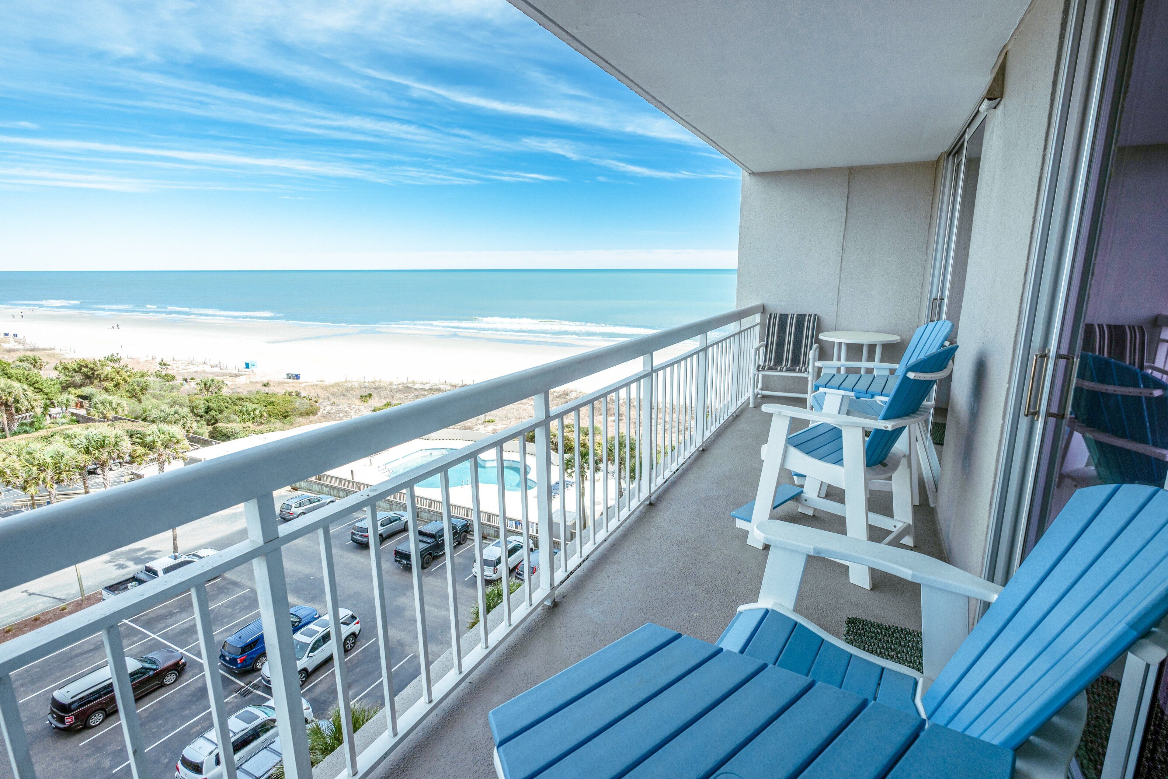 Ein Balkon mit Blick auf Strand und Meer.