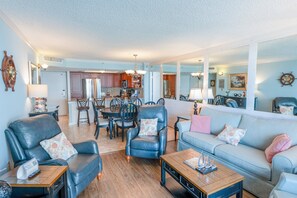 A spacious living room with a dining area, kitchen, and a large mirror reflecting the space. - 705 S Hampton Oceanview Retreat With Balcony 2 Bedroom Condo (Myrtle Beach)