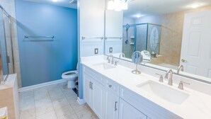 A modern bathroom with a walk-in shower, a toilet, a sink with a large mirror, and a towel rack. - 102 Royale Palms Oceanfront 2br Resort Access 2 Bedroom Condo (Myrtle Beach)