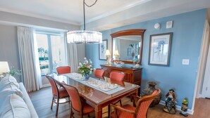 A dining area with a wooden table, red upholstered chairs, and a chandelier. - 102 Royale Palms Oceanfront 2br Resort Access 2 Bedroom Condo (Myrtle Beach)