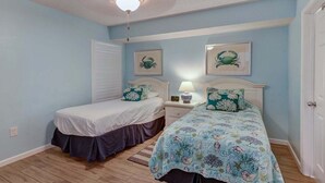 A bedroom with two beds, a ceiling fan, and a nightstand with a lamp. - Terrace At Pelican Beach 0804 3 Bedroom Condo (Destin)