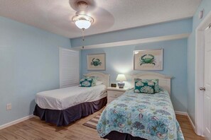 A bedroom with two beds, a ceiling fan, and a nightstand with a lamp. - Terrace At Pelican Beach 0804 3 Bedroom Condo (Destin)