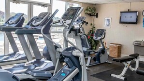 A gym with treadmills, a weight bench, and a TV on the wall. - Terrace At Pelican Beach 0804 3 Bedroom Condo (Destin)