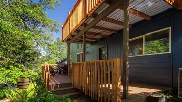 A wooden deck with a railing, a window, and a door.