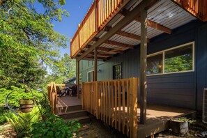 A wooden deck with a railing, a window, and a door. - Wake Robin House - Comfortable & Close To Campus 4 Bedroom Home (Eugene)