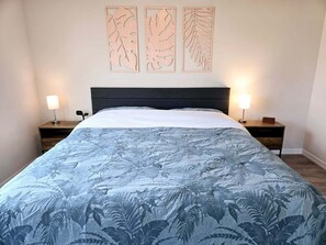 A bedroom with a bed, two bedside tables, and three wall-mounted light fixtures. - Moments From The Trail Pool Villa 3 Bedroom Home (Inverness)