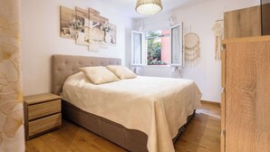 Ein Schlafzimmer mit Bett, Nachttischen, einem Fenster und Wanddekorationen.