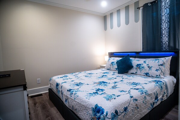 A bedroom with a bed, bedside table, and a nightstand.