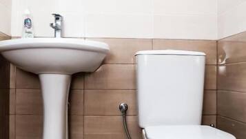 Quarto quádruplo conforto, sacada, vista para a cidade | Banheiro | Chinelos