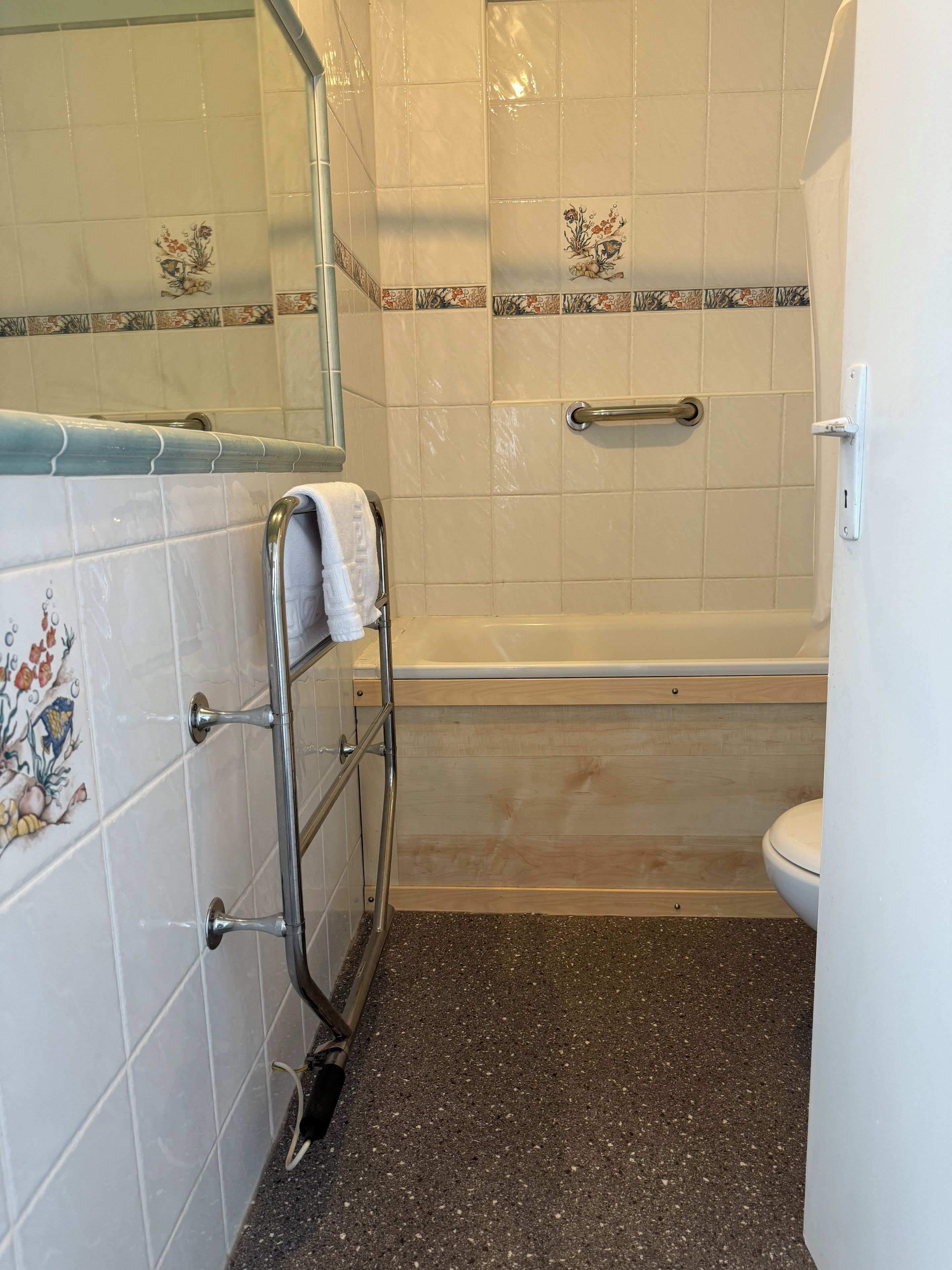 A bathroom with a bathtub, a toilet, and a shower area.