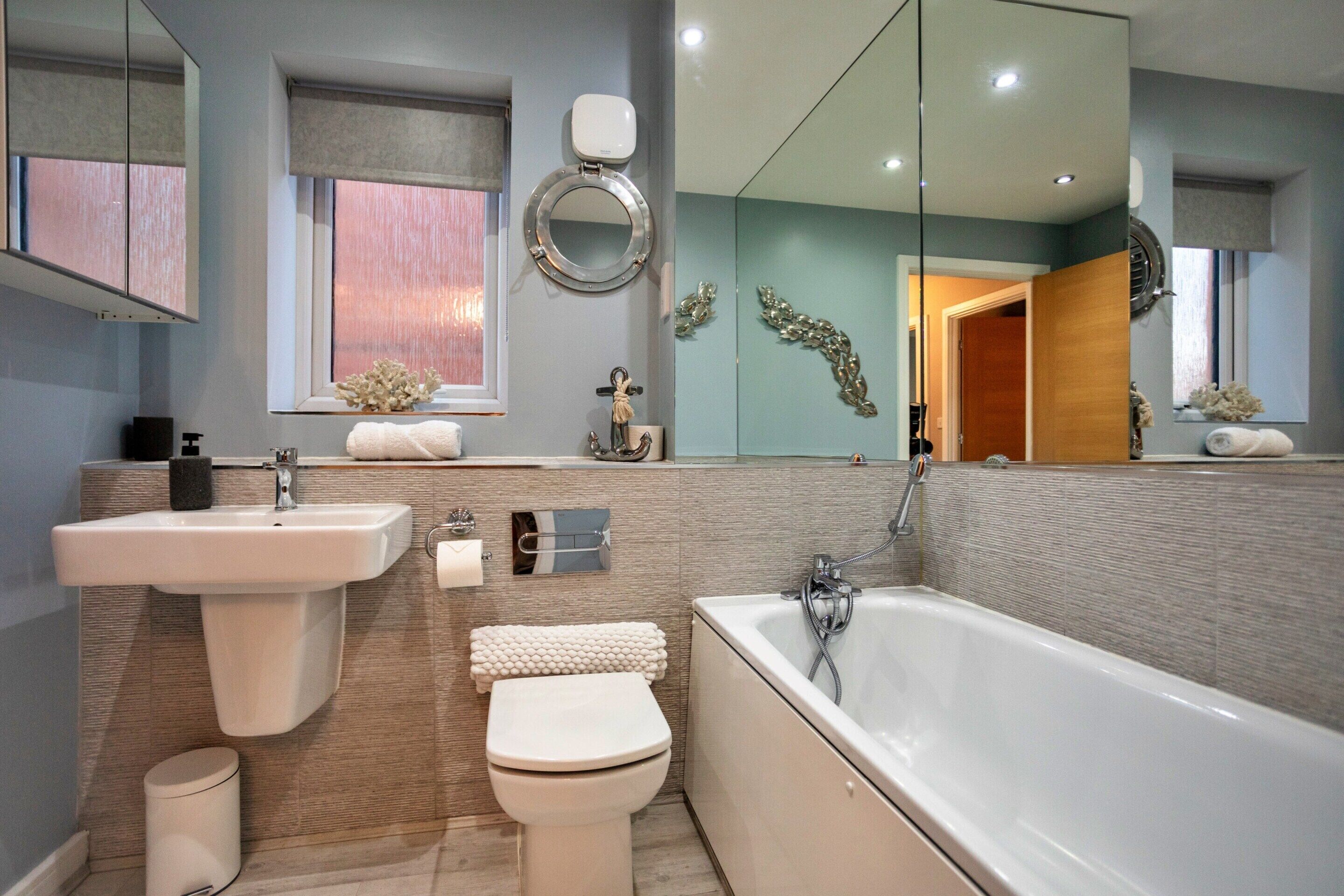 Un baño moderno con lavamanos, inodoro y bañera.