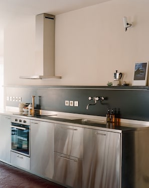 Eine moderne Küche mit Edelstahlgeräten, einem Backofen und einem Spülbecken.