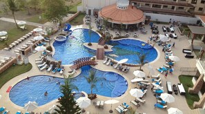 A multi-level pool area with various seating arrangements and a central bridge. - Amazing Oceanfront With Access Crocs Resort (Jacó)