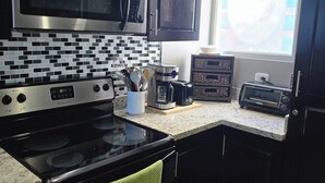 A kitchen with a stove, oven, microwave, and toaster. - Amazing Oceanfront With Access Crocs Resort (Jacó)