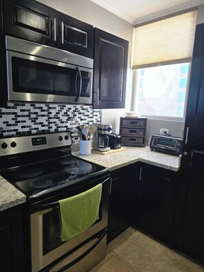 A kitchen with a stove, oven, microwave, and toaster. - Amazing Oceanfront With Access Crocs Resort (Jacó)